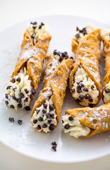 Chocolate chip cannolis dusted with powdered sugar