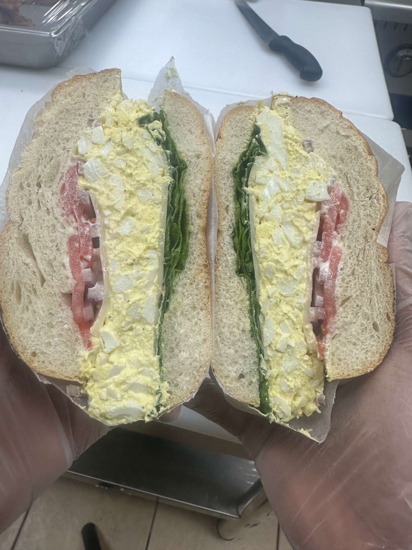 Egg salad sandwich with lettuce and tomato on a bagel